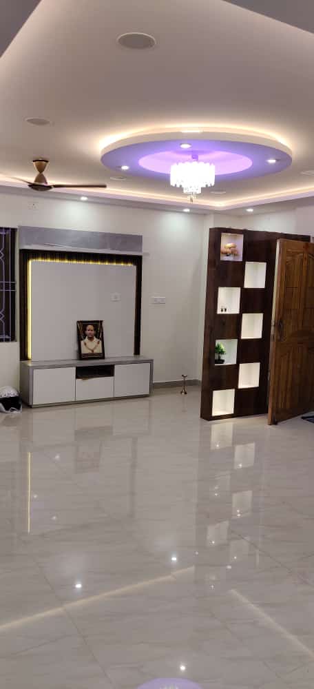 Spacious living room featuring circular POP ceiling chandelier and divider unit