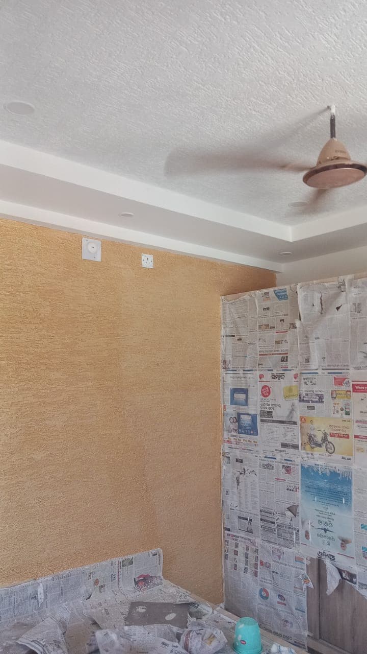 Warm textured accent wall with perimeter false ceiling cove lighting